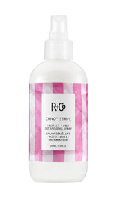 R+Co Candy Stripe Protect + Prep Detangling Spray bottle for quick detangling and protection.