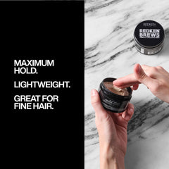 Hands applying Redken Brews Clay Pomade to sculpt volume and texture