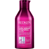 Redken Color Extend Magnetics shampoo bottle pouring to protect color vibrancy.