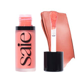 Saie Dew Liquid Blush Poppy application for a natural dewy flush.