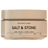 Salt & Stone Body Cream bottle front with warm saffron cedar scent promise.