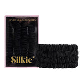 Silkie Noir four-pack silk scrunchies for snag-free styling.