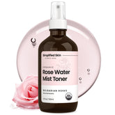 Spray de agua de rosas de Simplified Skin, botella en mano para hidratación suave.