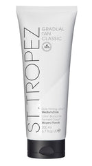 St. Tropez Gradual Tan Firming Lotion bottle shows buildable glow on skin.