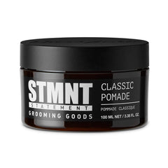 STMNT Grooming Goods Classic Pomade bottle close-up showing natural shine and strong hold.