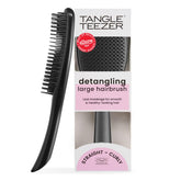Tangle Teezer Large Ultimate Detangler with wide paddle gliding through wet or dry hair for smoother results.
