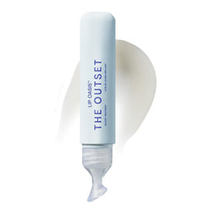 The Outset Lip Oasis lip balm tube open, ready to hydrate dry lips with a glassy finish.