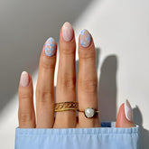 Uñas falsas Tnbuokas en forma almendra con lazo blanco y acabado brillante.