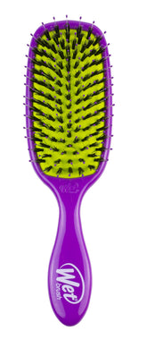 Wet Brush Shine Enhancer bottle in hand highlights its purple design and easy grip.