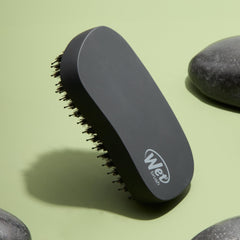 Wet Brush Shine Enhancer in hand demonstrates palm-sized ergonomic grip for easy styling