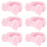 WHAVEL banda spa rosa con lazo para mantener el cabello durante la limpieza facial.