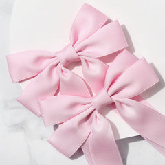 Aileam pink bow with sturdy alligator clip for reliable hair styling.