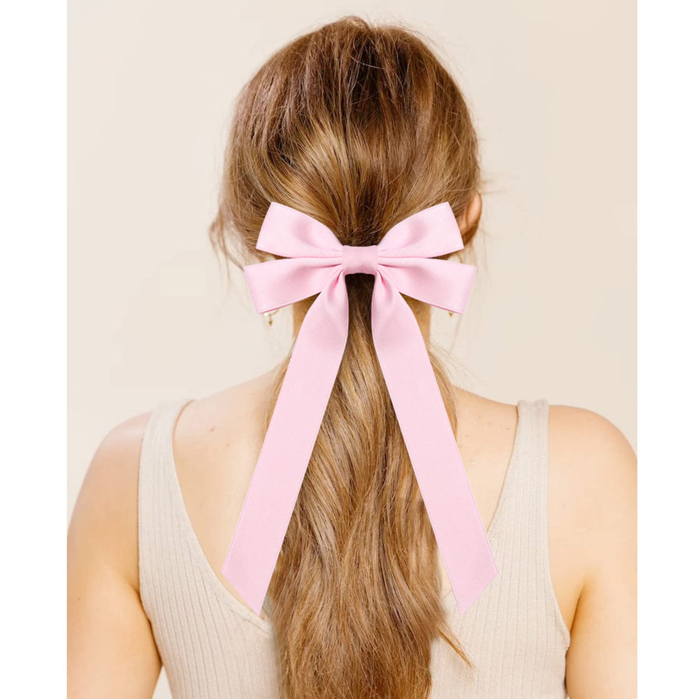 Aileam pink satin bow worn on headband for stylish look.