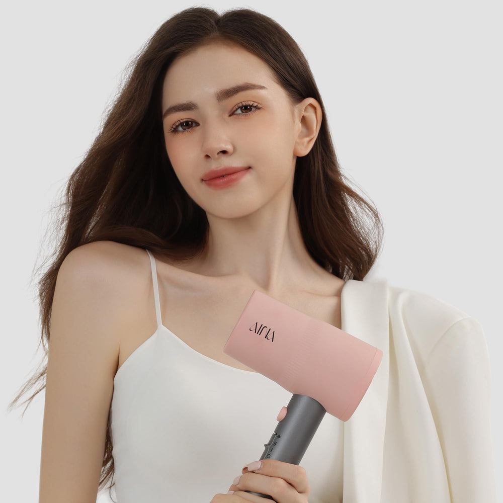 Aina Misty Blush hair dryer with cold shot to lock style.