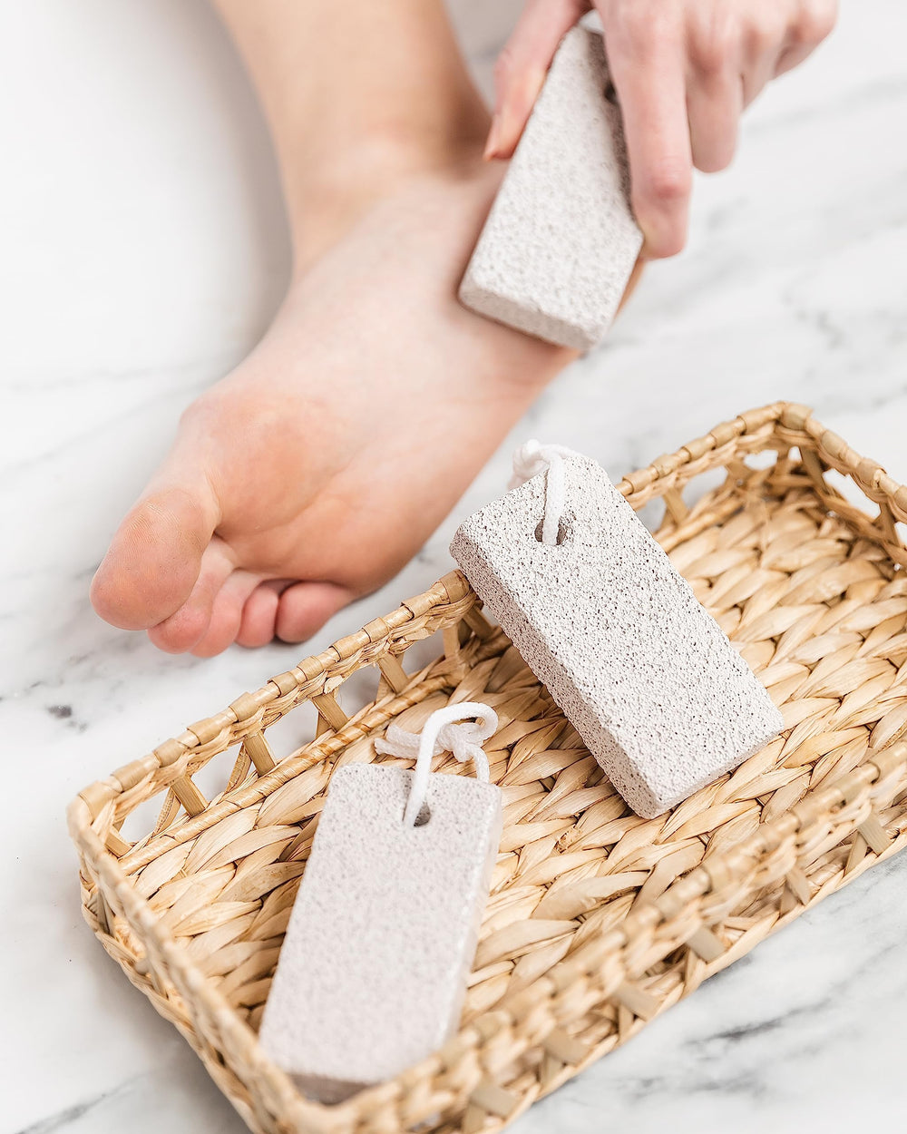 Using the smoothing stone on heels to soften rough skin.