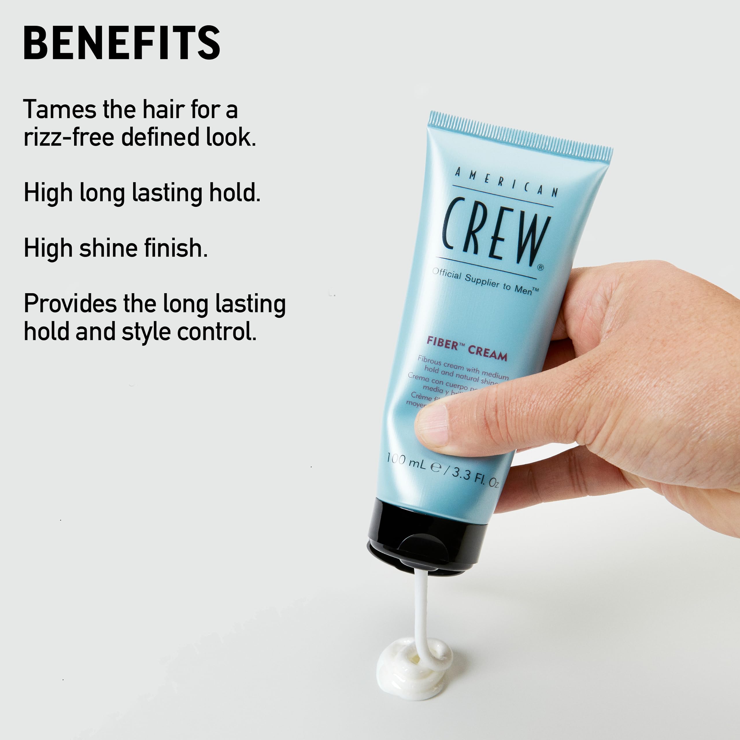 Hands applying American Crew Fiber Cream to damp hair for textured control.