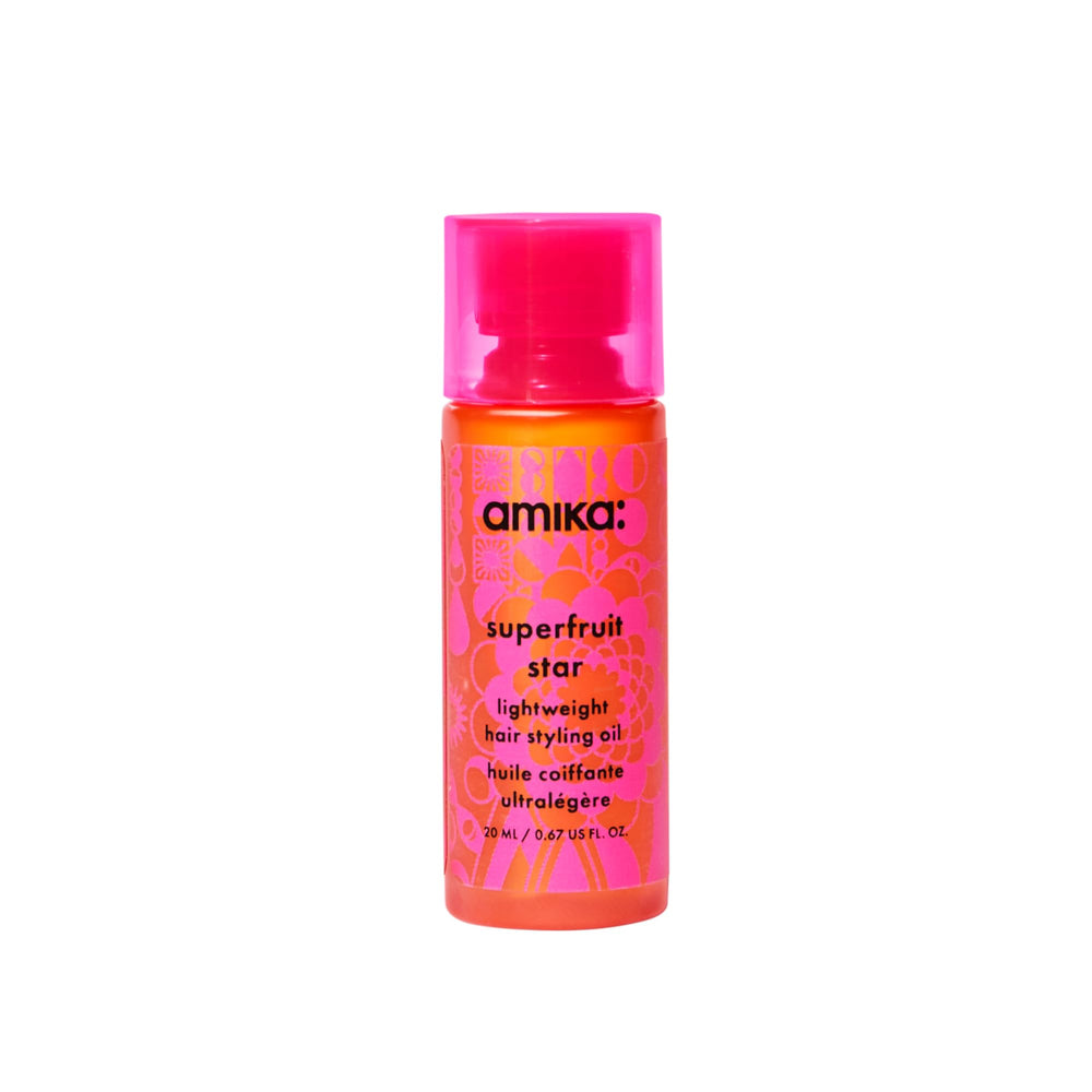 Amika Superfruit Star Oil bottle pours to apply protective hair care.