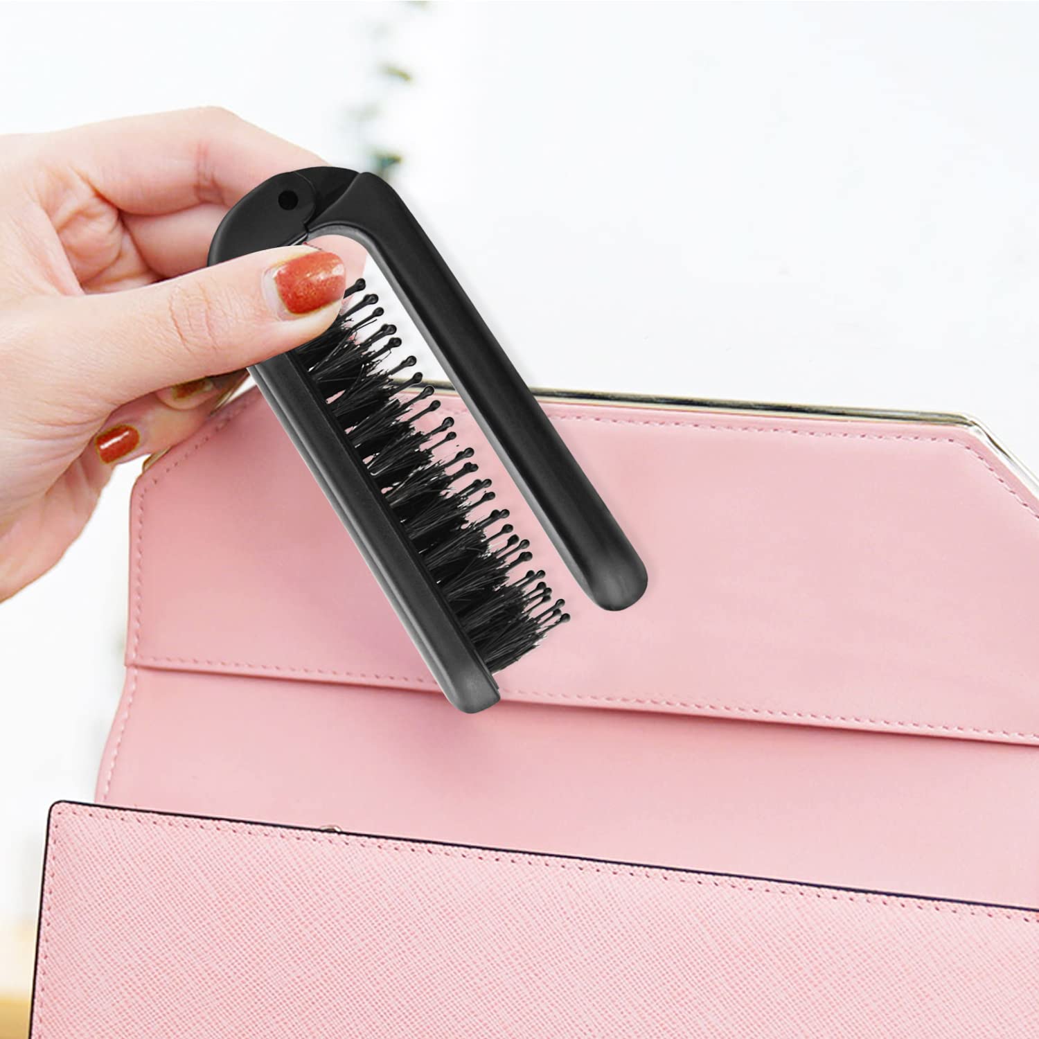 Ancable folding brush tucked into pocket or purse for travel