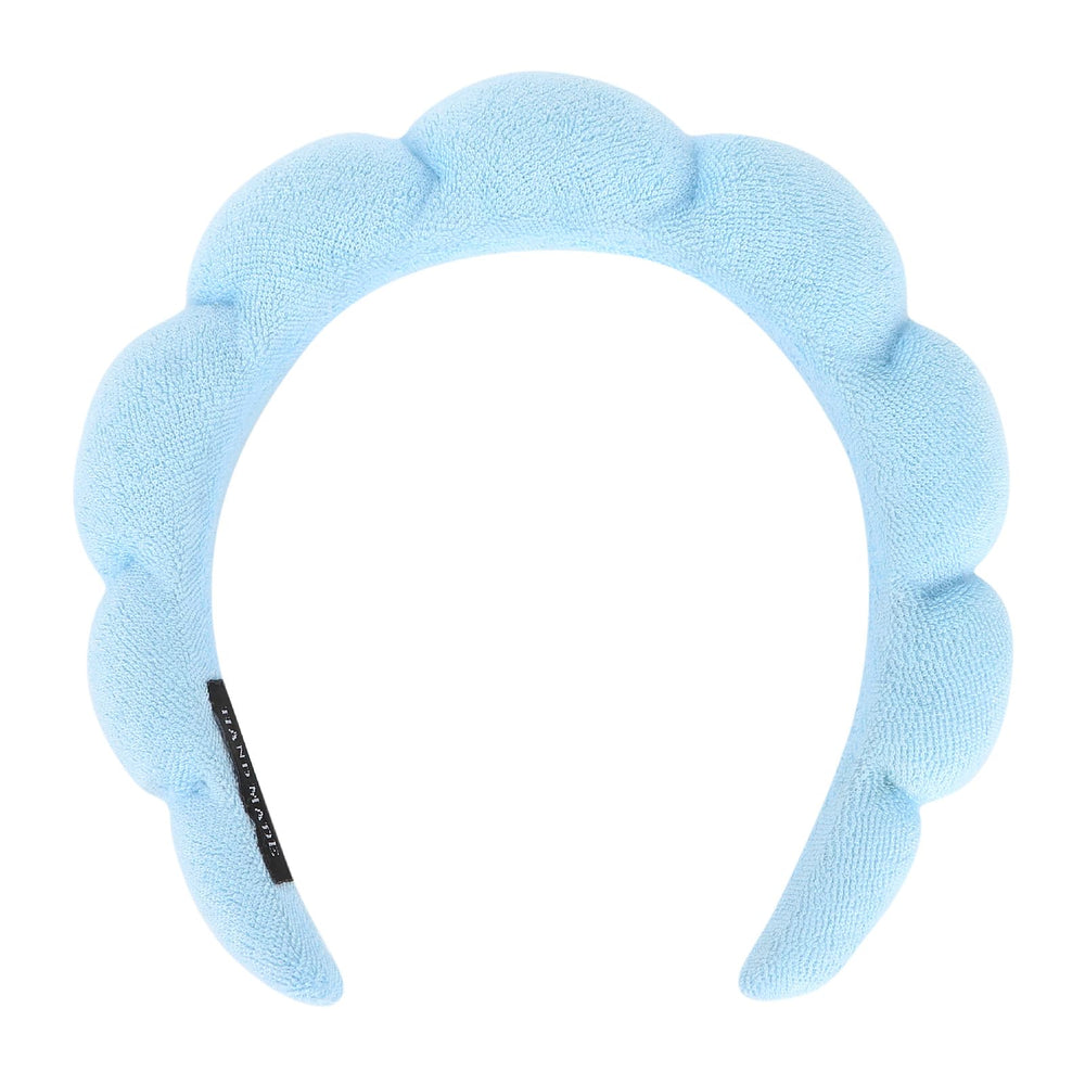 Araluky blue fluffy headband with flower-like design keeps hair dry during cleansing.