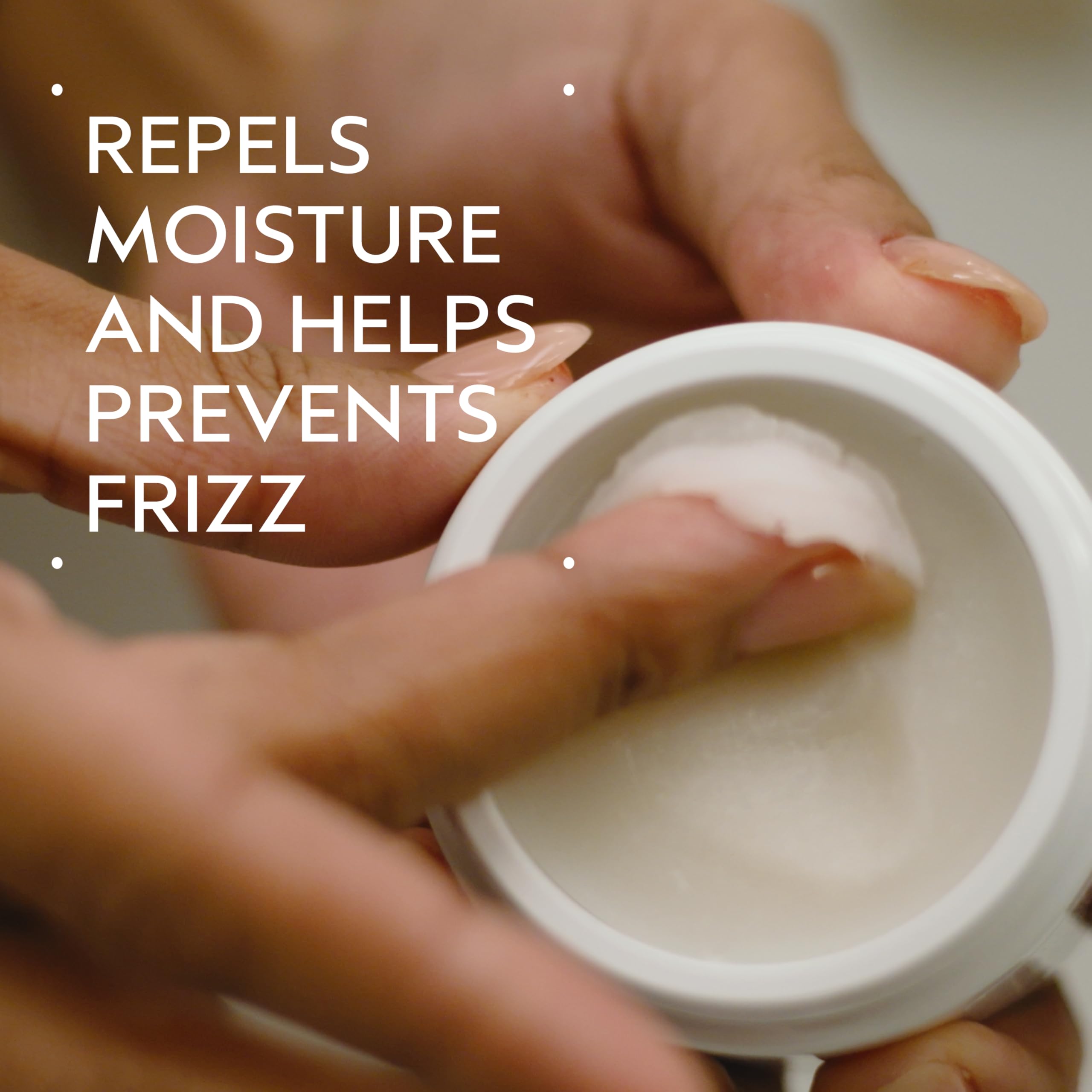 Aveda pomade jar demonstrating emulsification between hands for application.