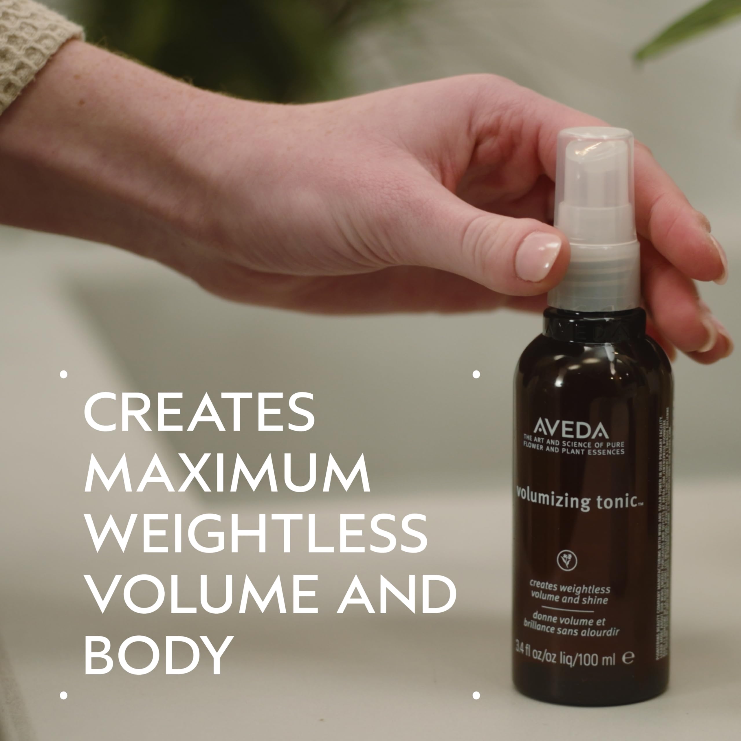 Applying Aveda Volumizing Hair Tonic to damp hair for lift