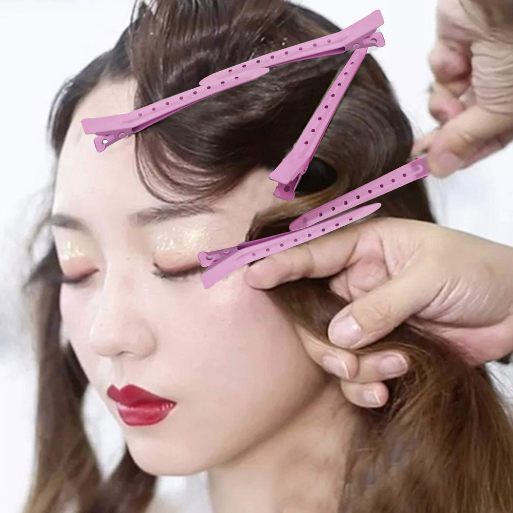 Bantoye pink duck bill clip being used to hold curls in place.