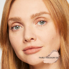 Application with brush showing light, creamy texture of foundation