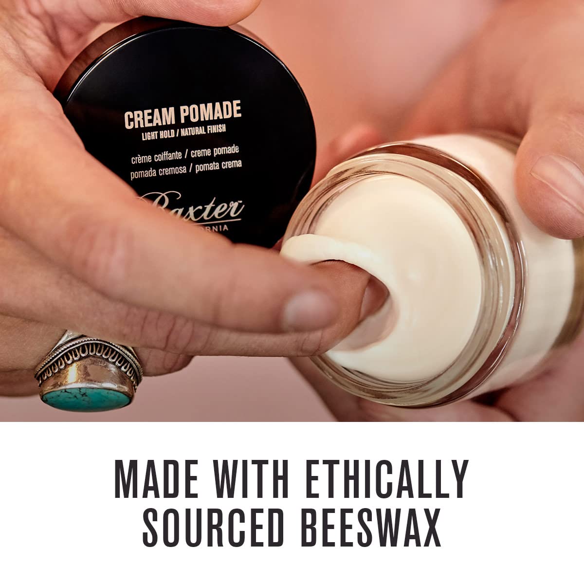 Hands apply Baxter of California Cream Pomade for light hold on hair.