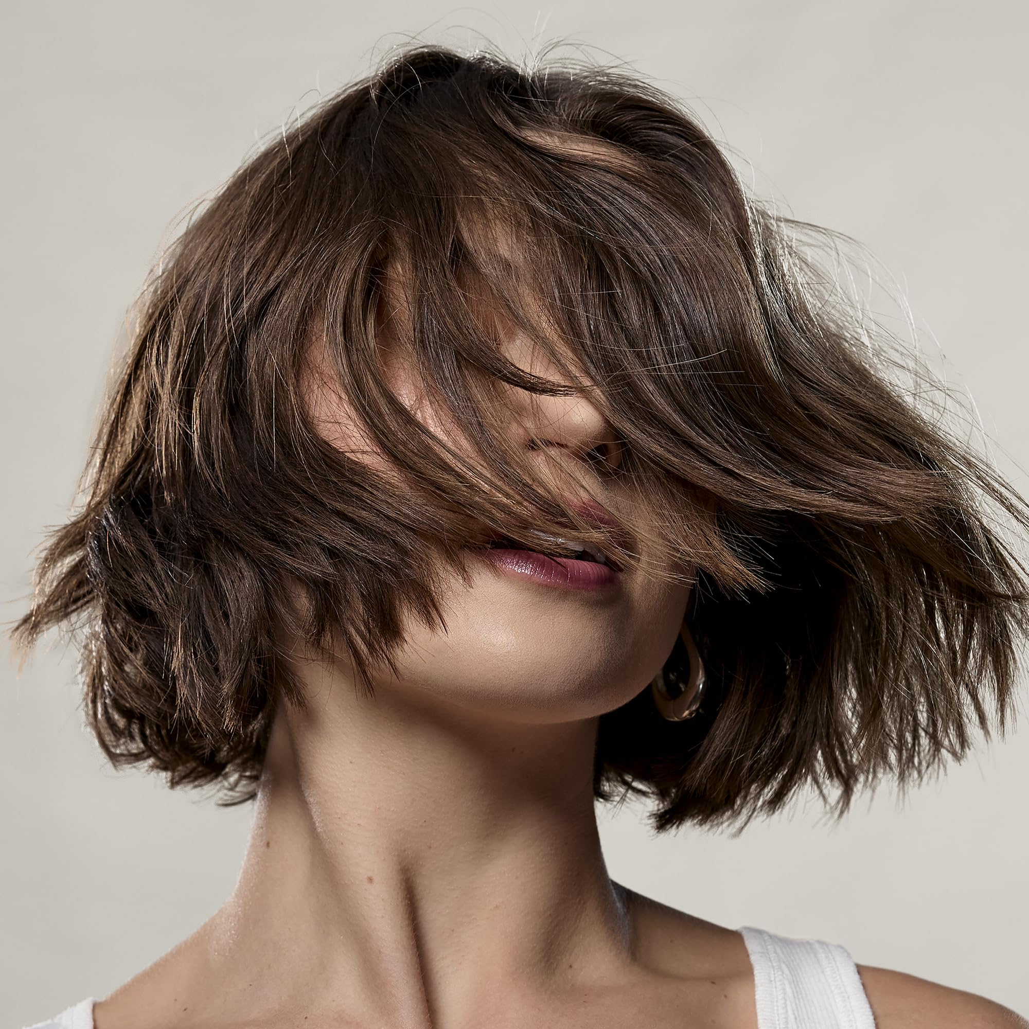 Daily-use setup with bottle and mirror implies versatile, easy texture for everyday styling