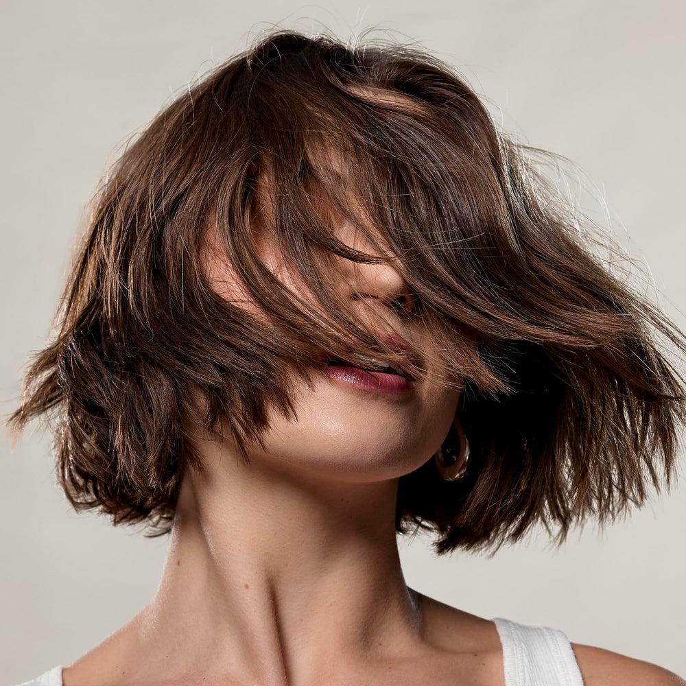 Daily-use setup with bottle and mirror implies versatile, easy texture for everyday styling