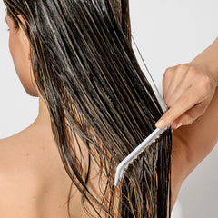 Creamy Bumble and bumble conditioner texture swirl ready for detangling.