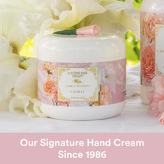 Hands applying Camille Beckman glycerine hand therapy cream showing easy absorption.