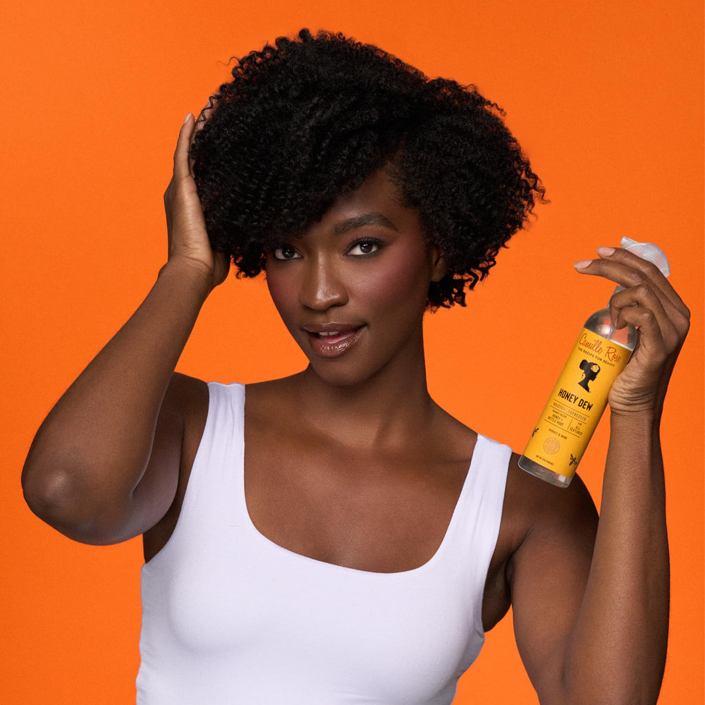 Camille Rose Curl and Detangler Spray being applied to curls for detangling.
