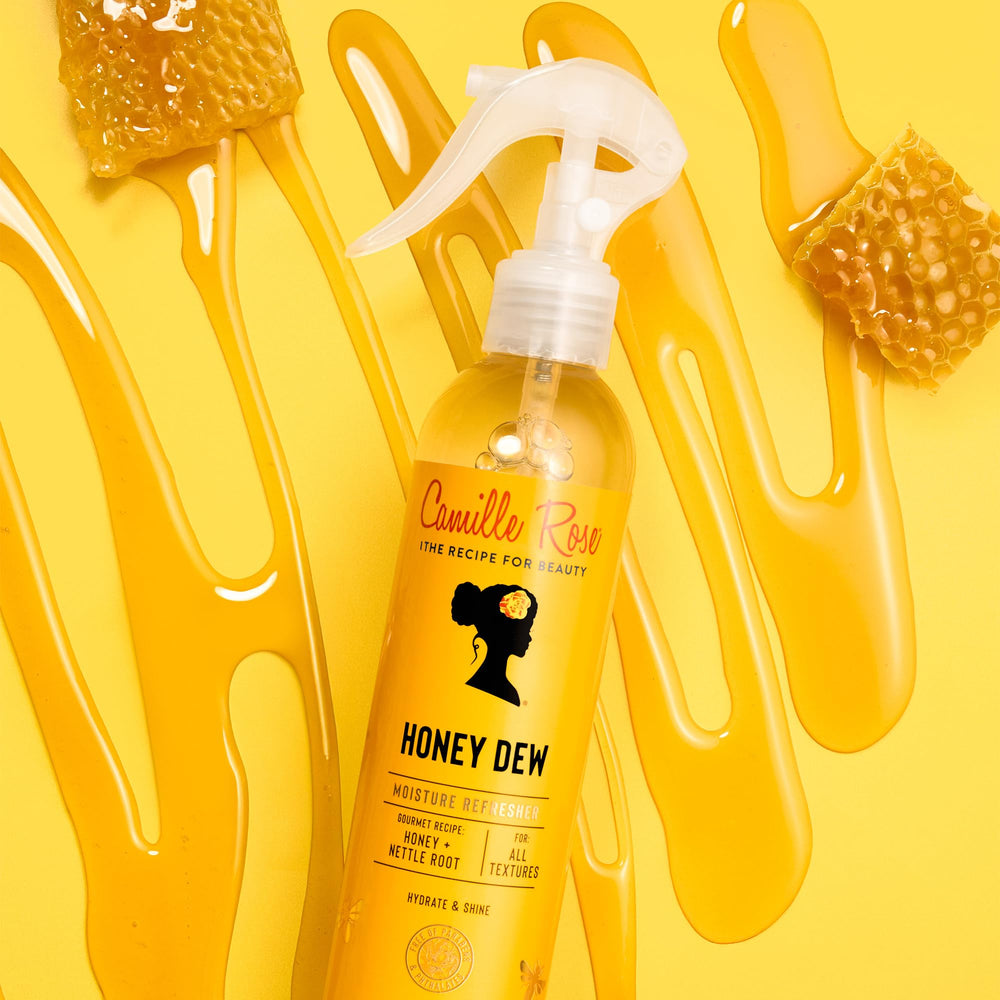 Camille Rose Curl and Detangler Spray ingredients close-up with honey and rice water.