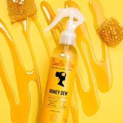 Camille Rose Curl and Detangler Spray ingredients close-up with honey and rice water.