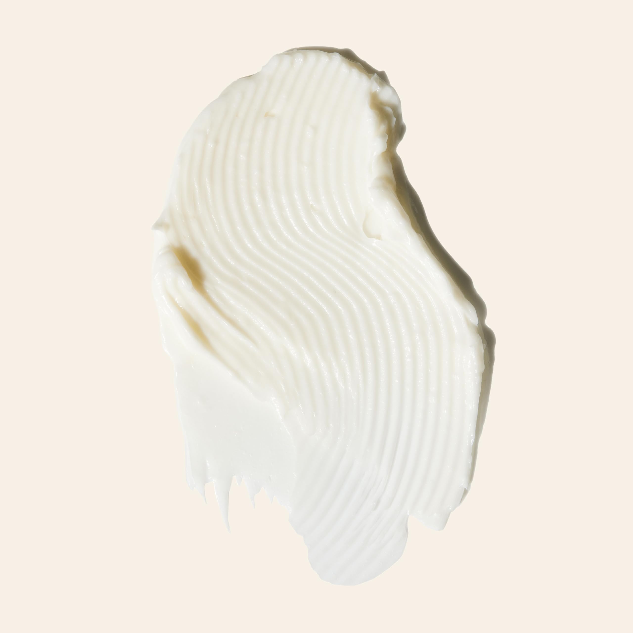 Mujer con cabello ondulado usando Goddess Strength Balm para definición