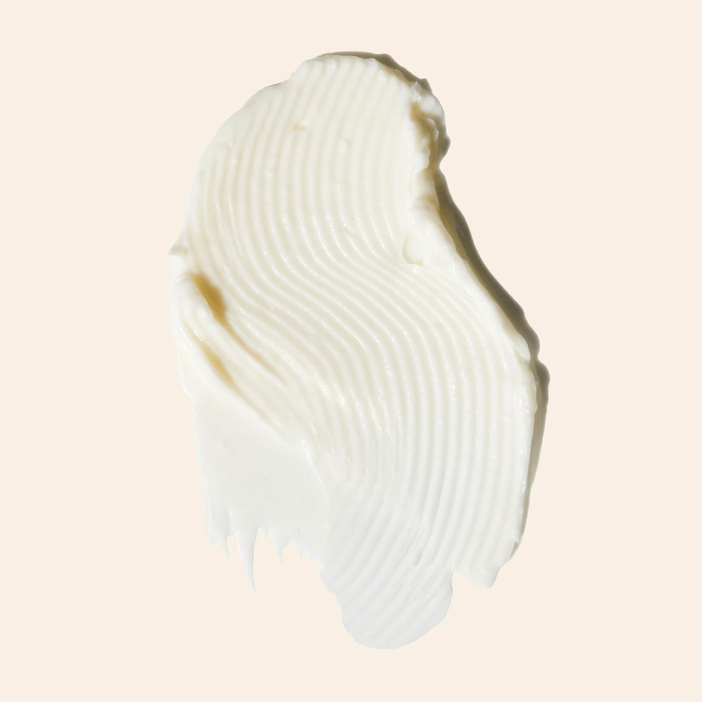 Mujer con cabello ondulado usando Goddess Strength Balm para definición