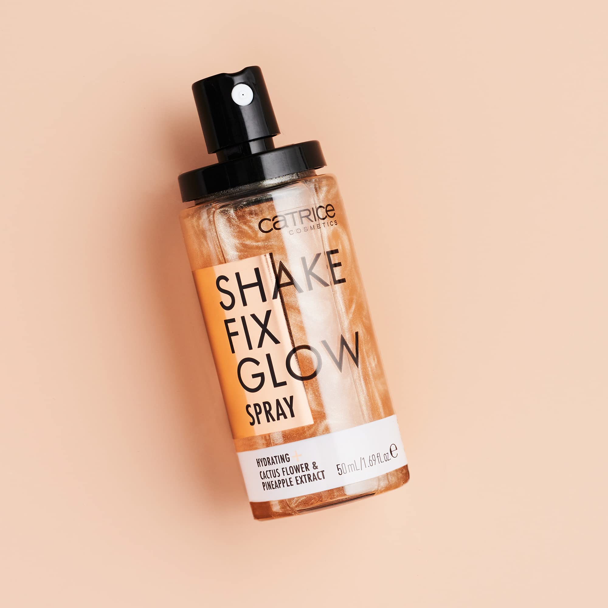 Catrice Shake Fix Glow Spray application tips on mirror for quick touch-ups.