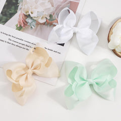 Cellot bows attached to clips displayed for quick styling in daily looks.
