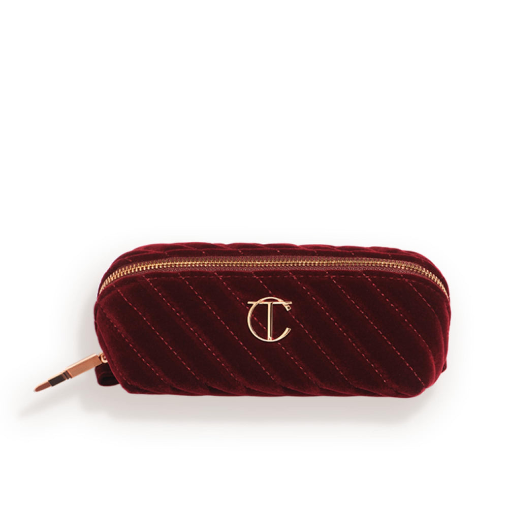 Charlotte Tilbury mini travel makeup bag in night crimson velvet for on-the-go touch-ups.