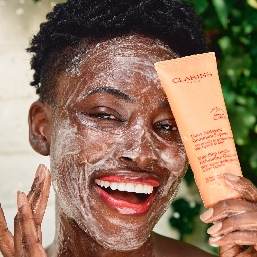 Applying Clarins One-Step Gentle Exfoliating Cleanser to the face during routine
