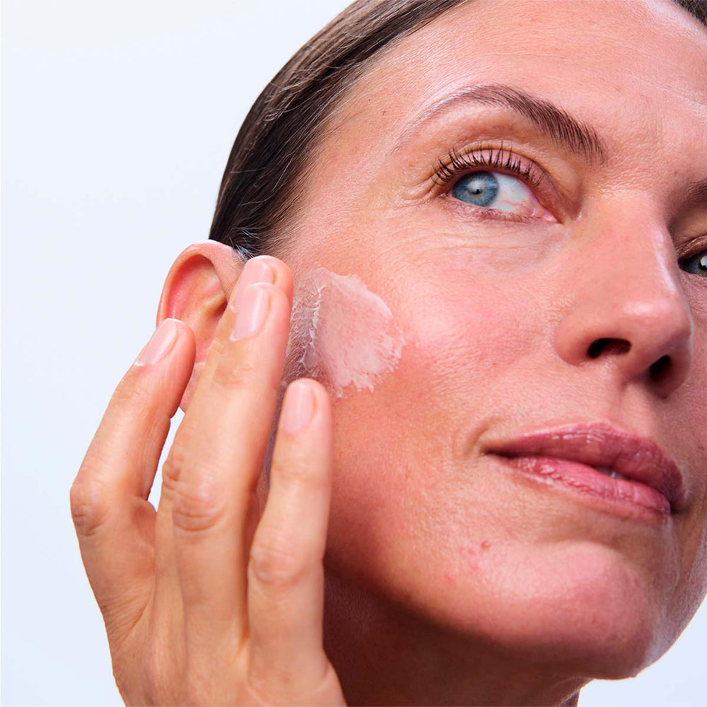 Clarins Super Restorative Day Cream being spread on skin demonstrates smoothing and brightening potential.