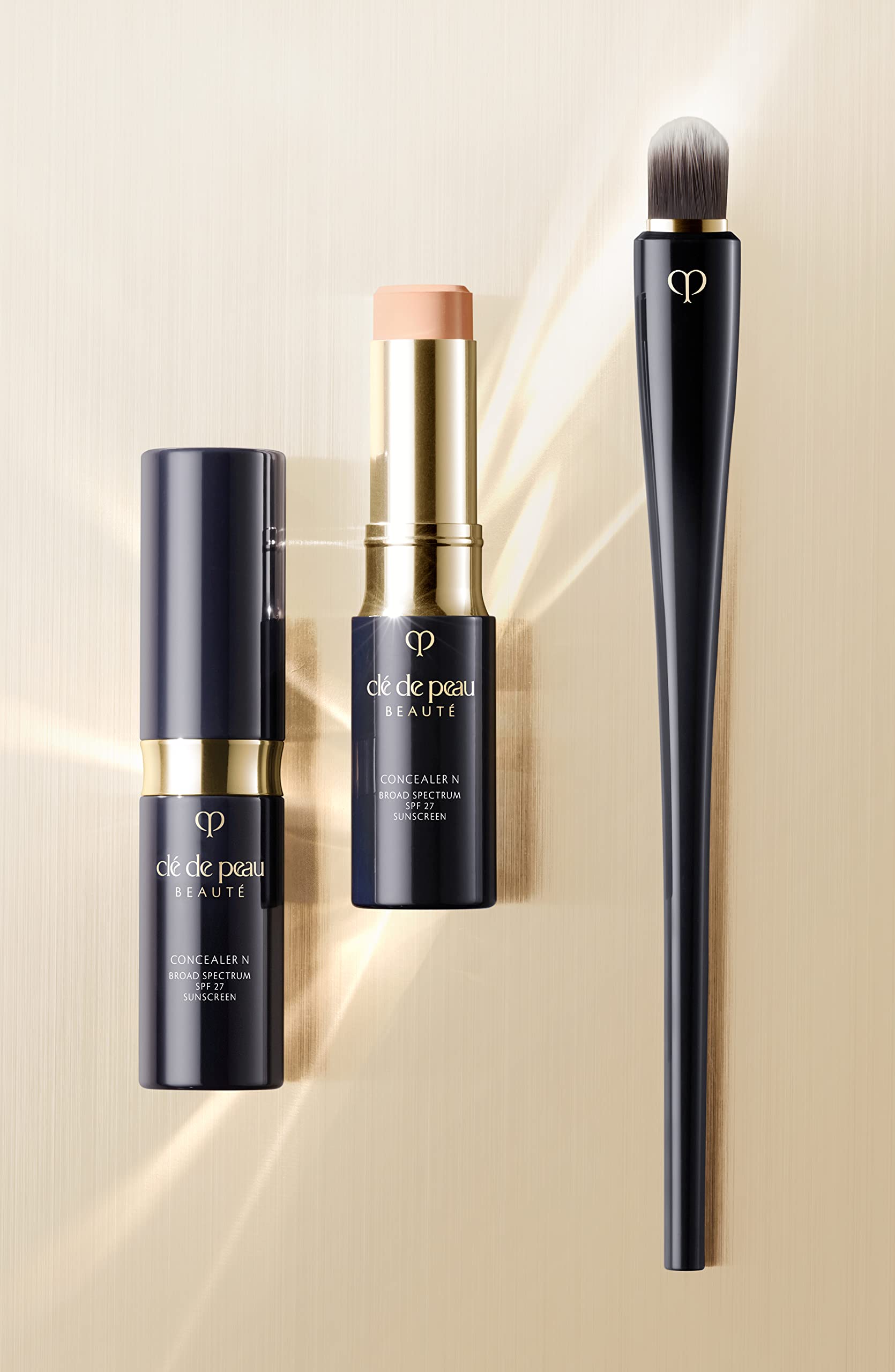 Clé de Peau Beauté Concealer SPF 27 Ivory being touched-up for quick coverage.