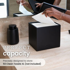 Clean Skin Club cement box on countertop with towels, offering stable, space-saving storage.
