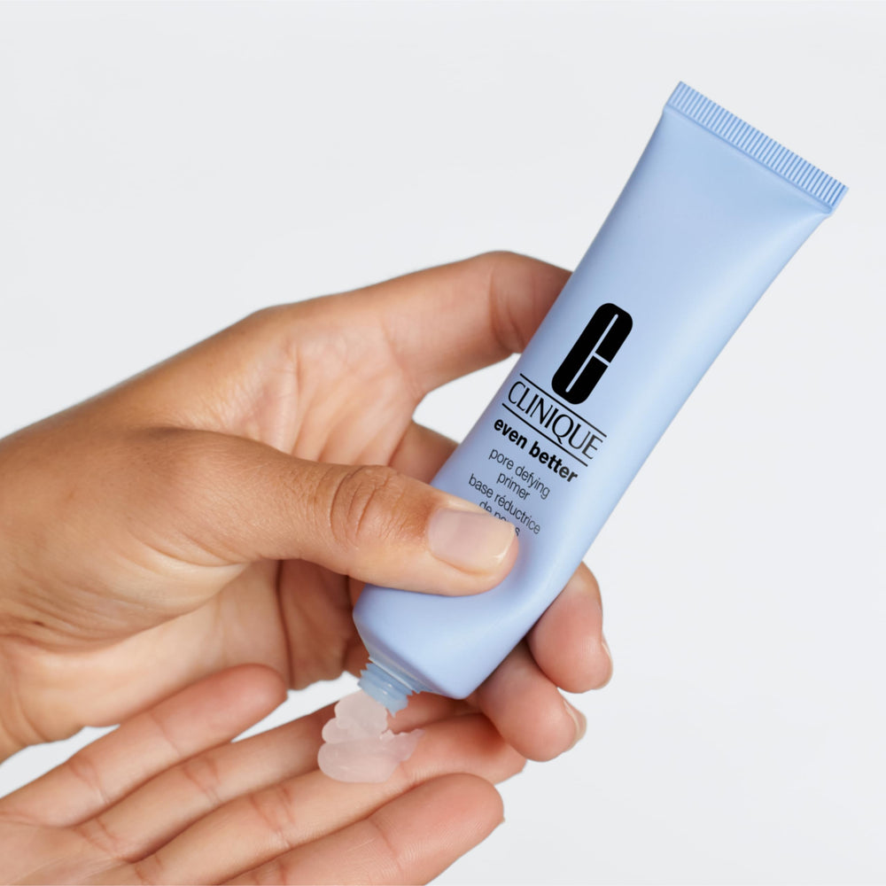 Clinique face primer tube on desk conveys skin-friendly formula for pore minimization.