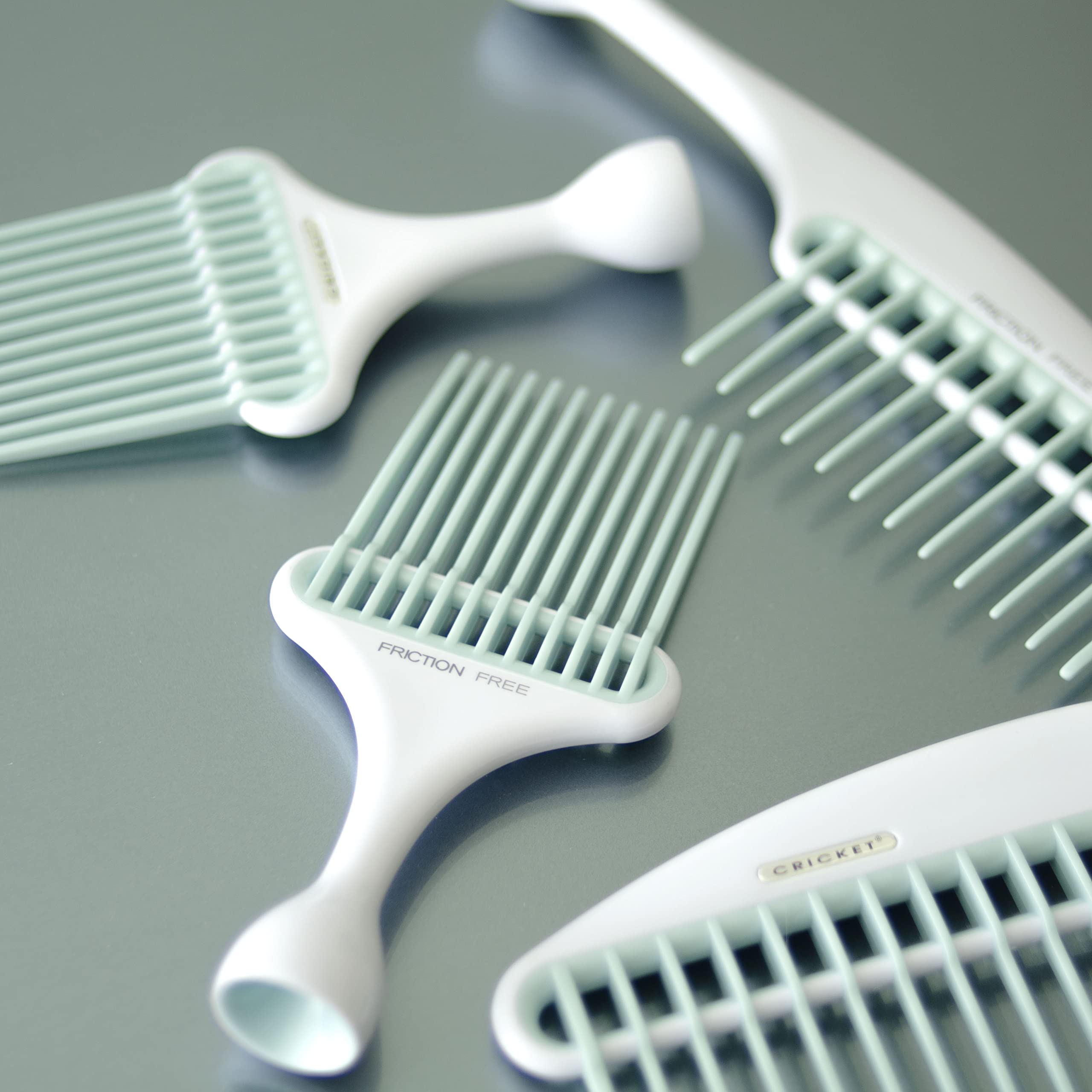 Cricket Friction Free Pick Comb with non-slip handle held in hand.