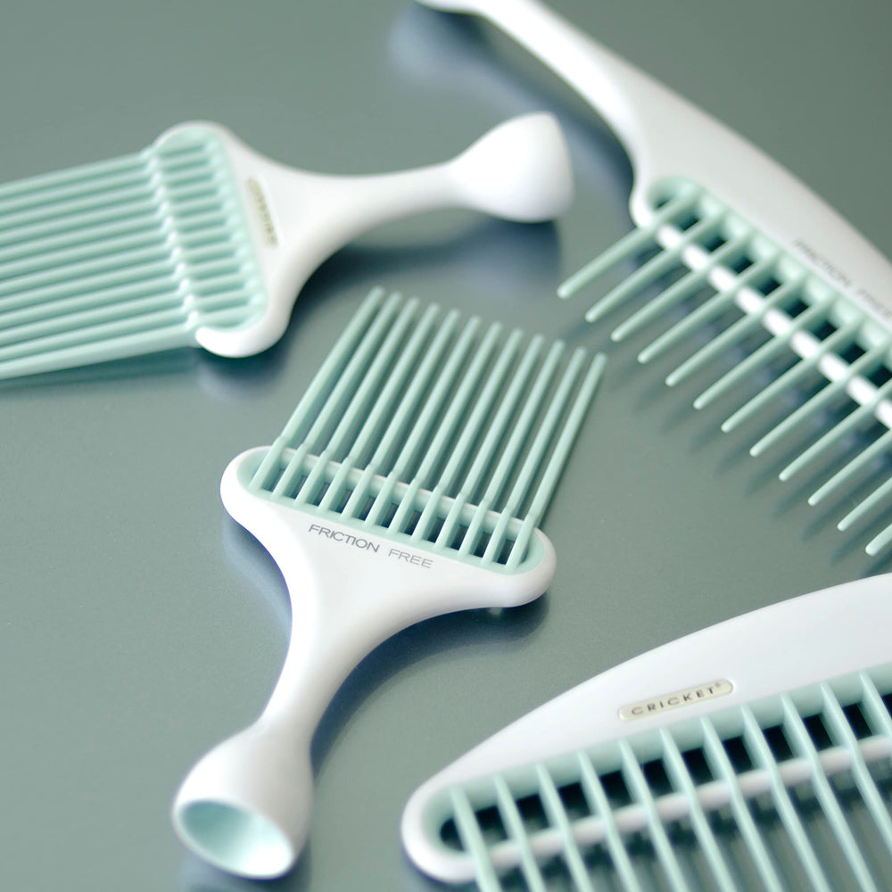 Cricket Friction Free Pick Comb with non-slip handle held in hand.