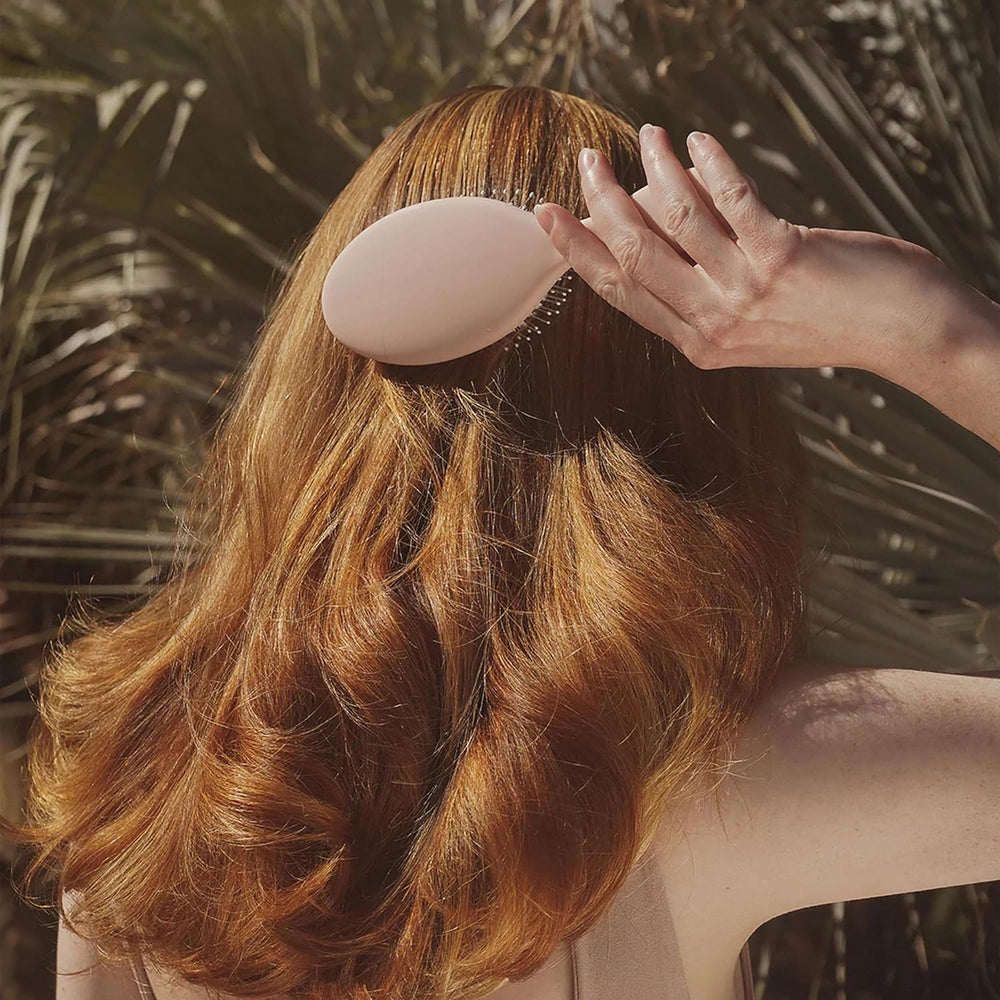DAE vegan detangle brush in hand for everyday routine