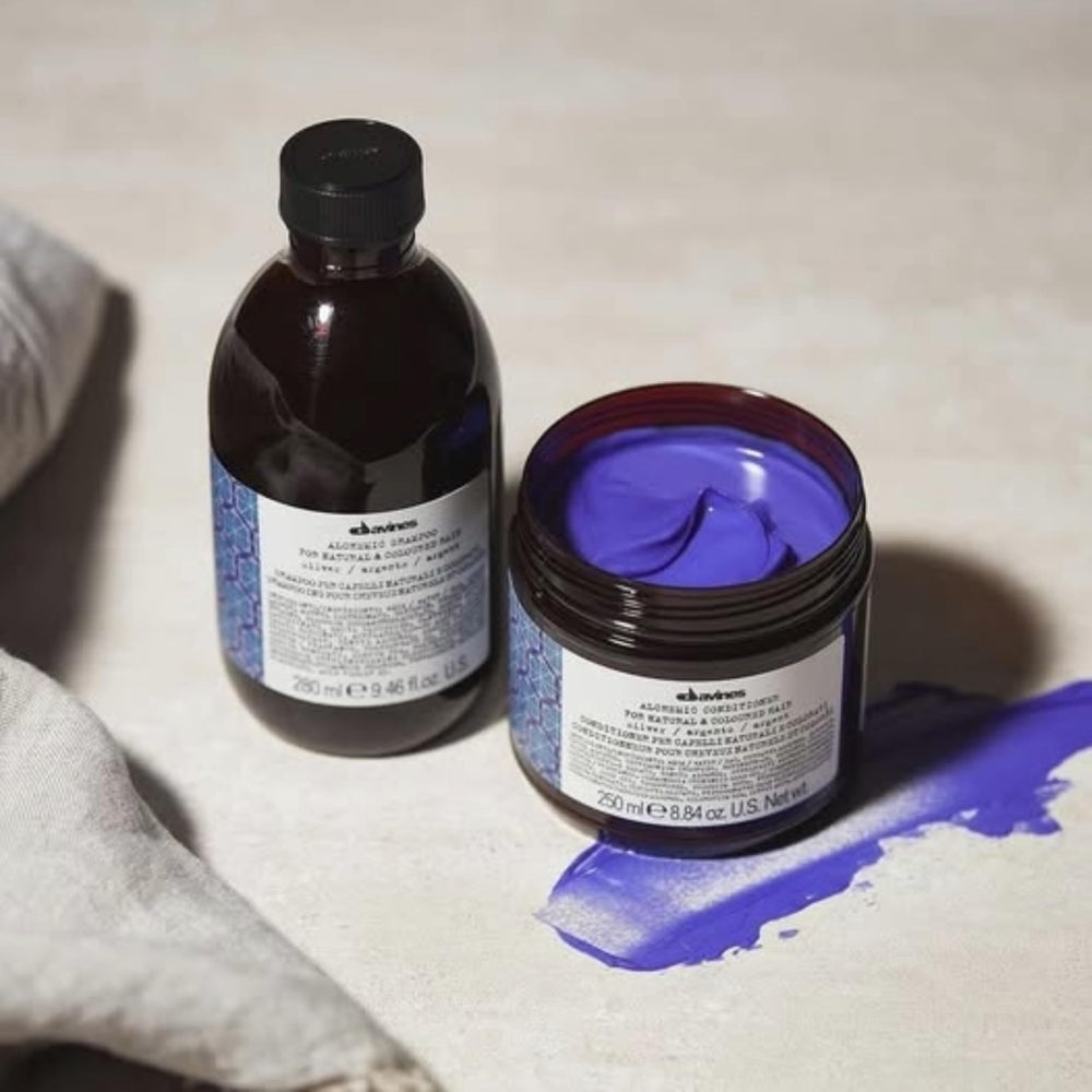 Davines Alchemic Shampoo Silver bottle on a sunlit shelf, suggesting color protection.