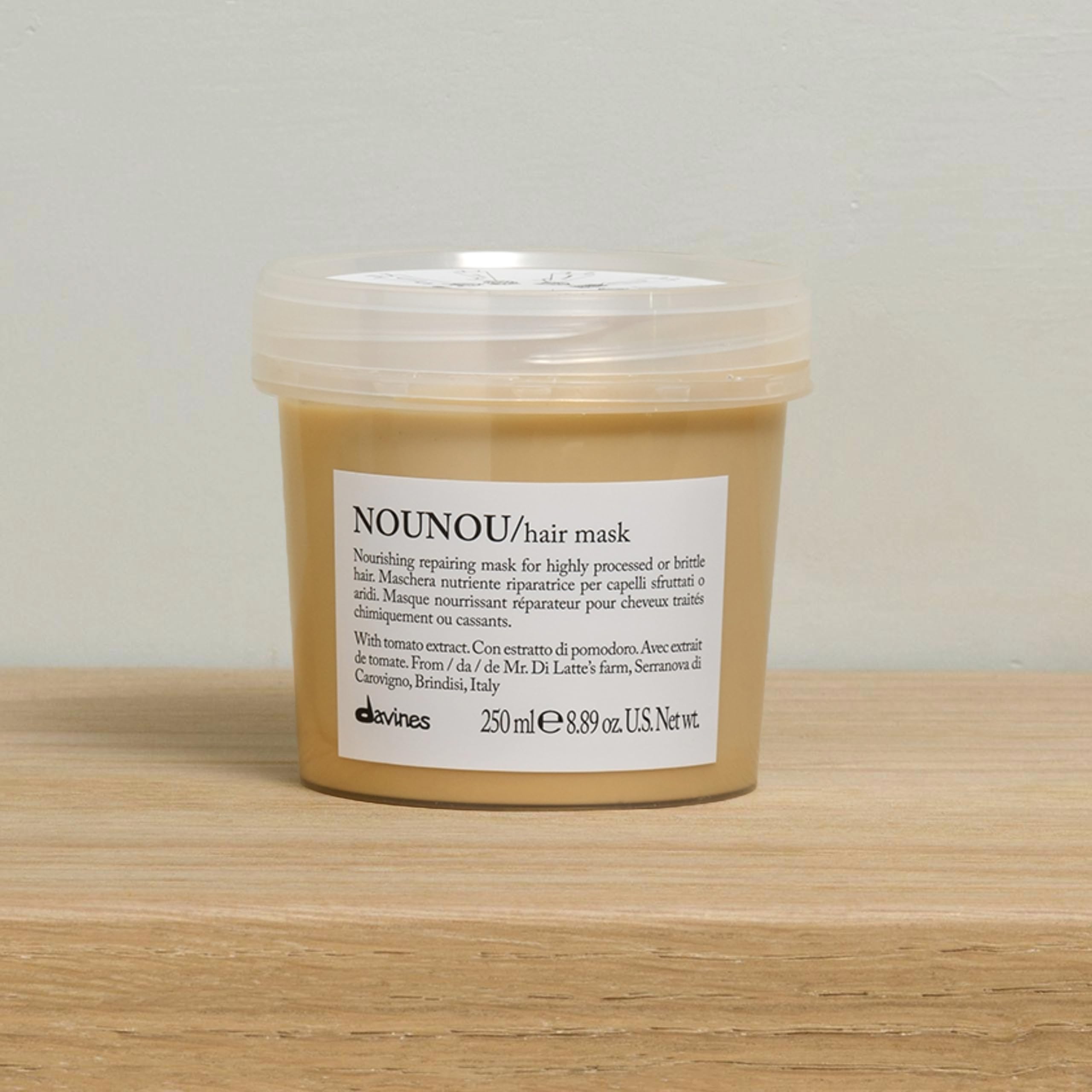 Davines Nounou Hair Mask packaging on wood surface signals premium repair for damaged hair.